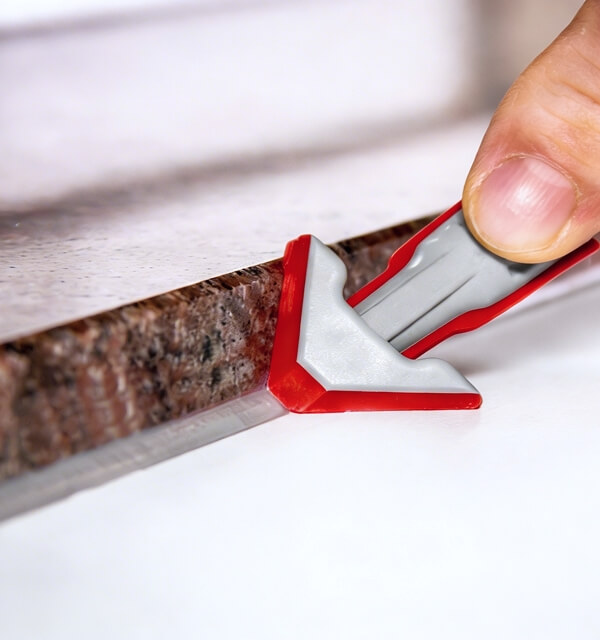 Close-up of a red REGGA nozzle applying silicone.