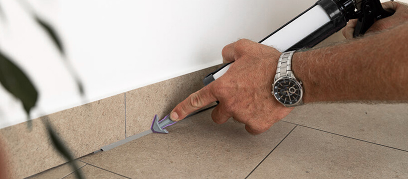 Use of a REGGA nozzle on a caulking gun for sealing tiles in a floor corner
