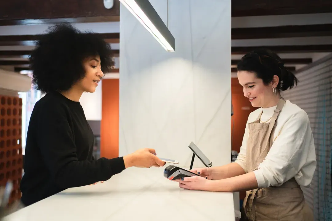 Shop owner taking a card payment from a customer