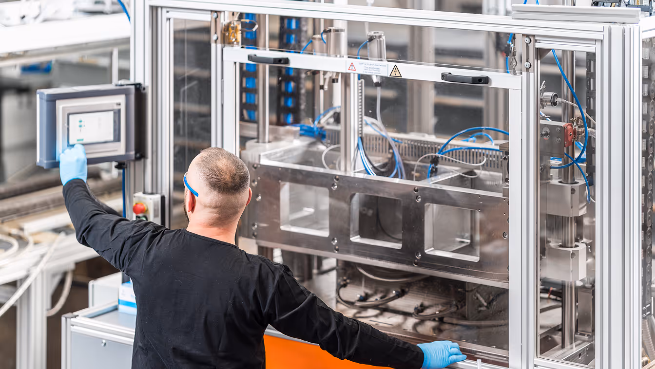 BIONTEC employee operating a manufacturing machine in production