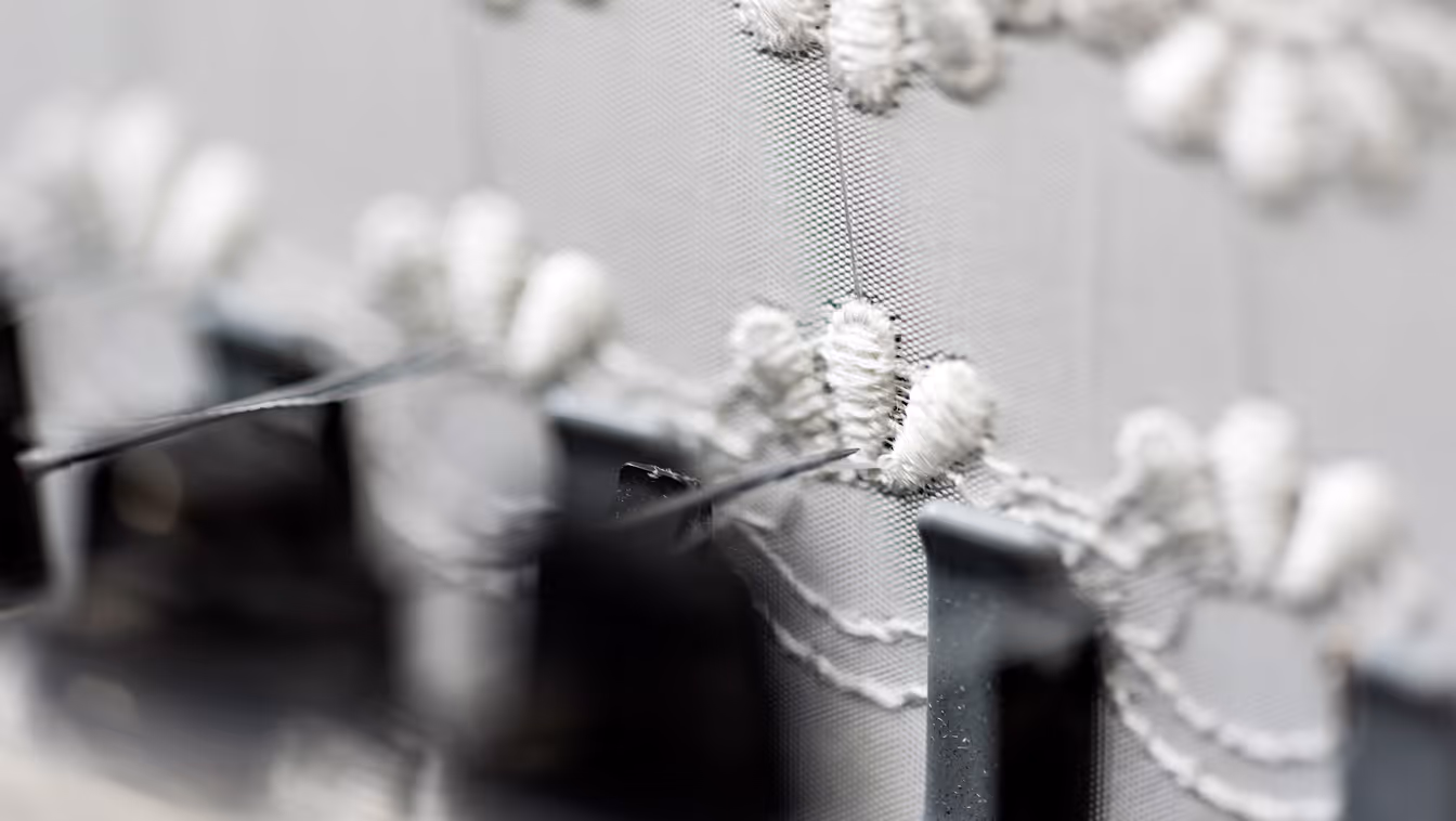Close-up of the embroidery technology: continuous fibers precisely placed on a backing material at BIONTEC
