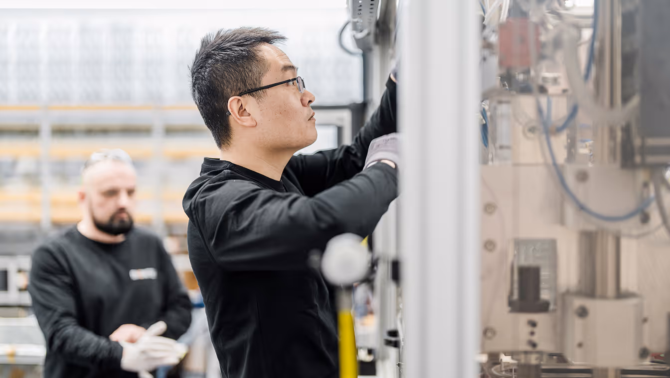 Two BIONTEC employees working at a composite production machine