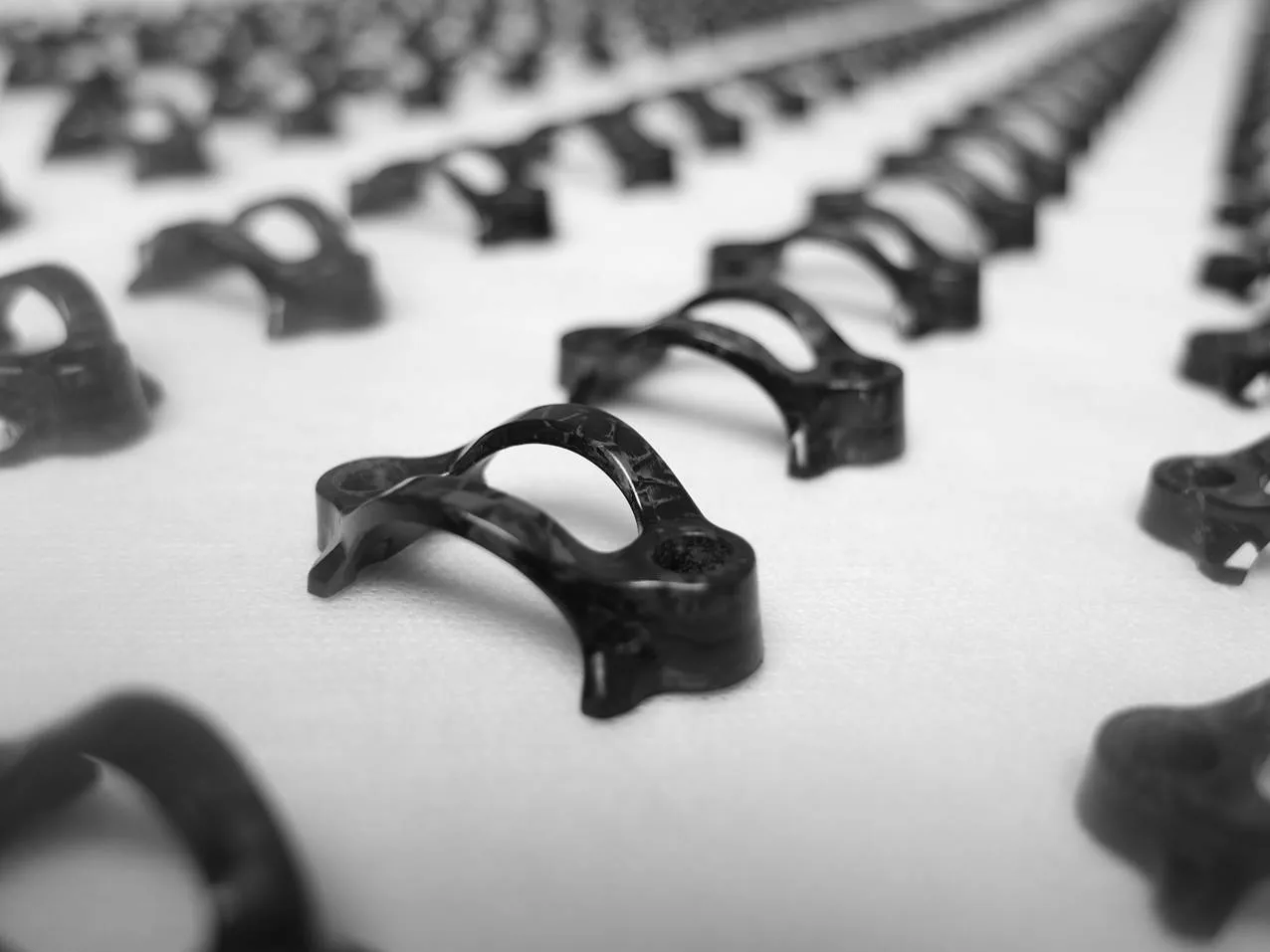 Rows of black composite clamps, black-and-white photo