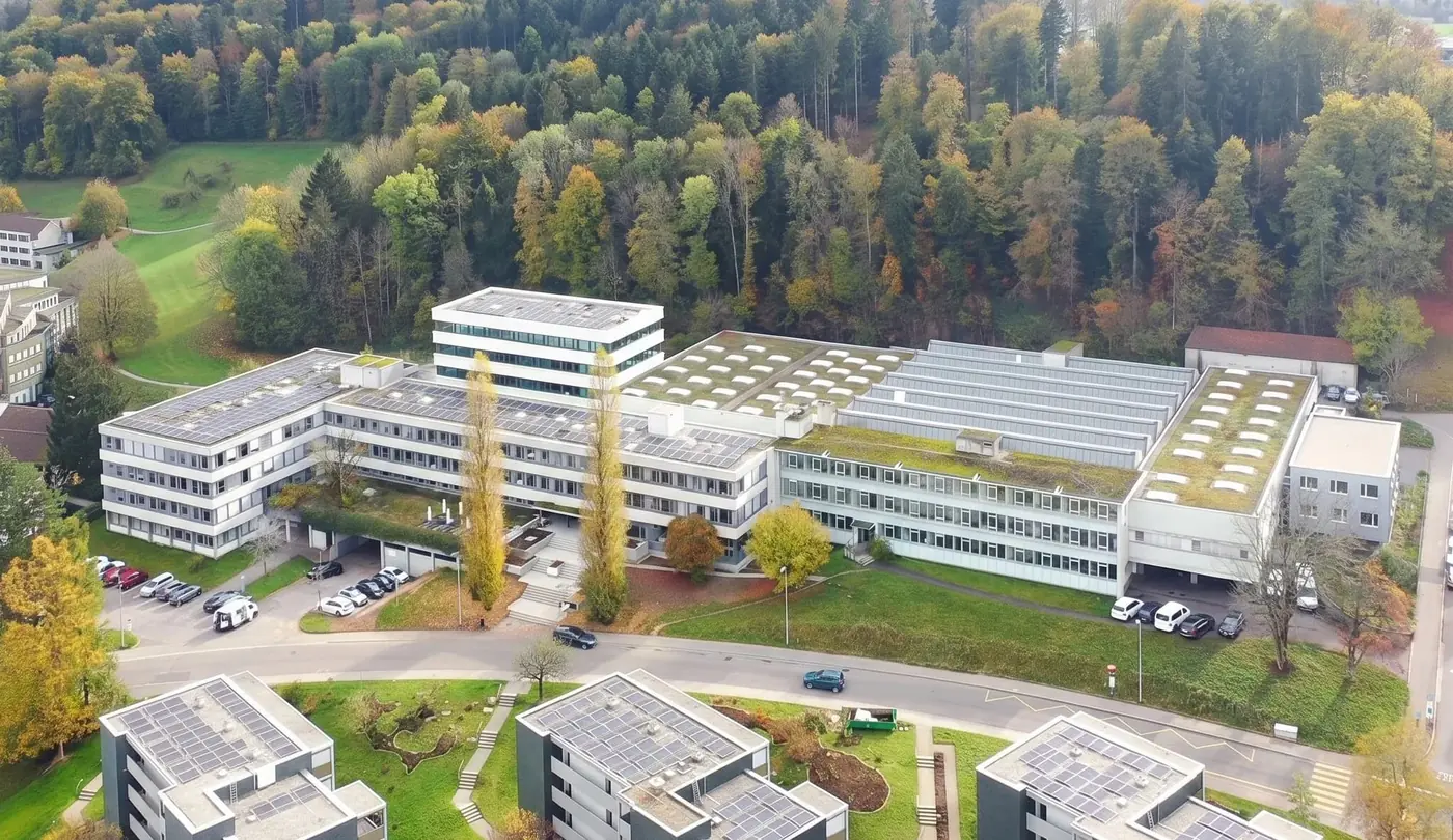 Aerial view of BIONTEC headquarters in a forested landscape