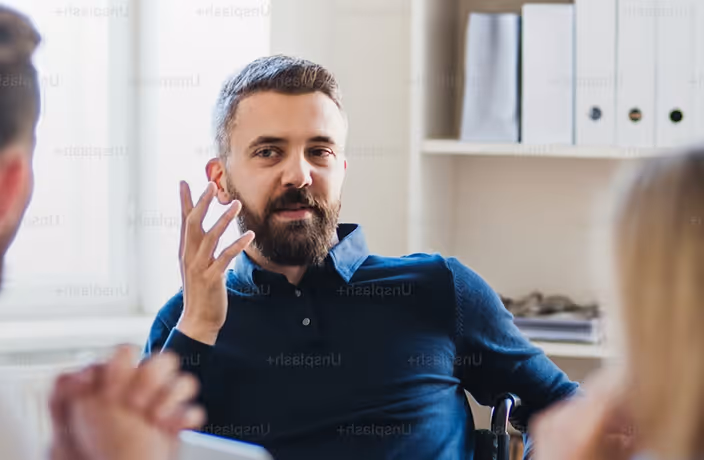 A man talking to a woman in a chair.