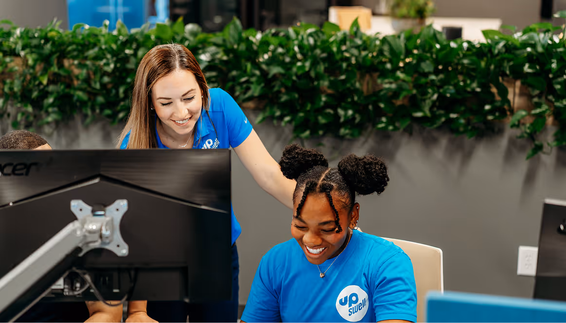 A woman and a girl looking at a computer screen.