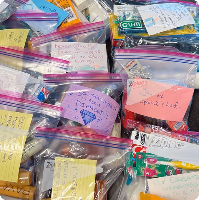Plastic bags filled with toiletries and handwritten motivational notes with positive messages.