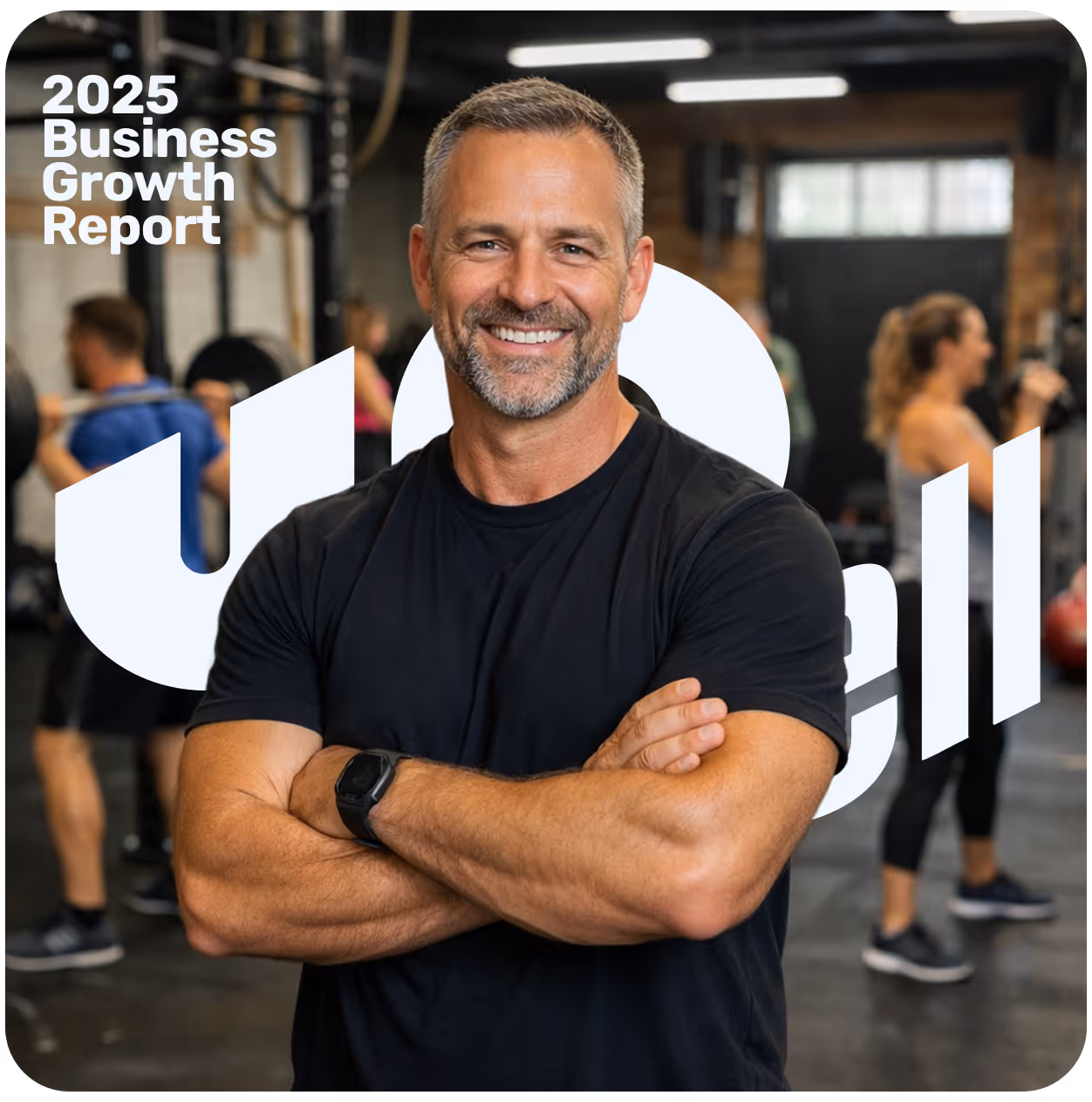 Smiling muscular man in black shirt with smartwatch stands with arms crossed in a gym with people working out.