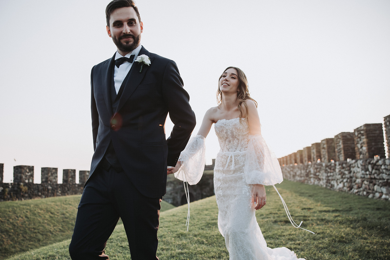 Bride and groom walking along Rocca di Lonato’s ancient walls