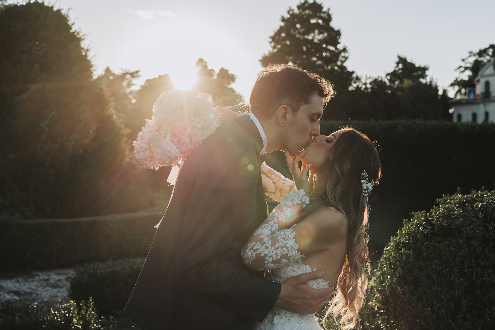 Bride and groom kissing at sunset in Villa Valmarana gardens
