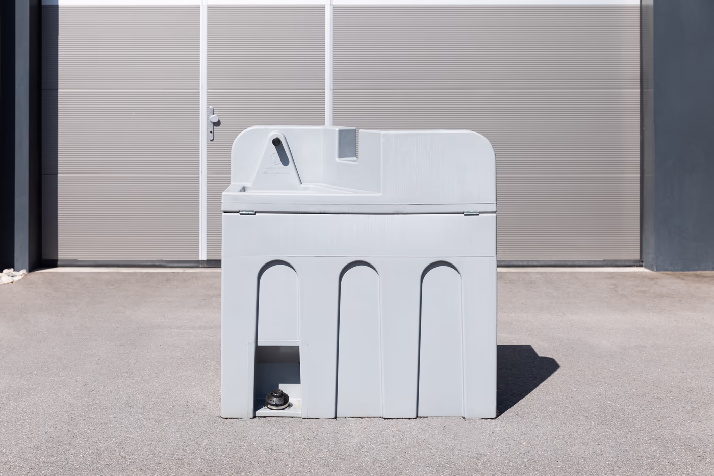 Un lavabo mobile gris. Une pédale au sol permet d'enclencher le débit de l'eau