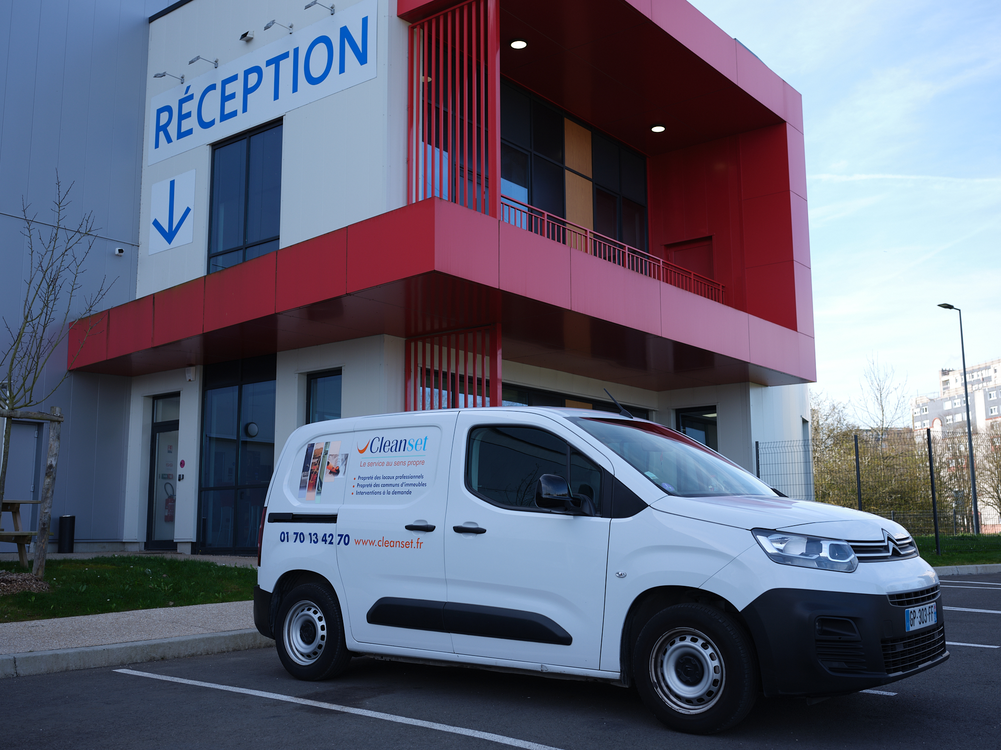 Fourgonnette CleanSet garée devant l'entrée d'un bâtiment d'entreprise, assurant la réactivité de nos services en Île-de-France.