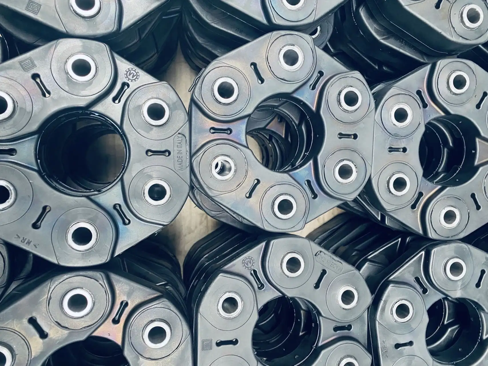 Close-up view of stacked black mechanical couplings with metal inserts and hexagonal shapes.