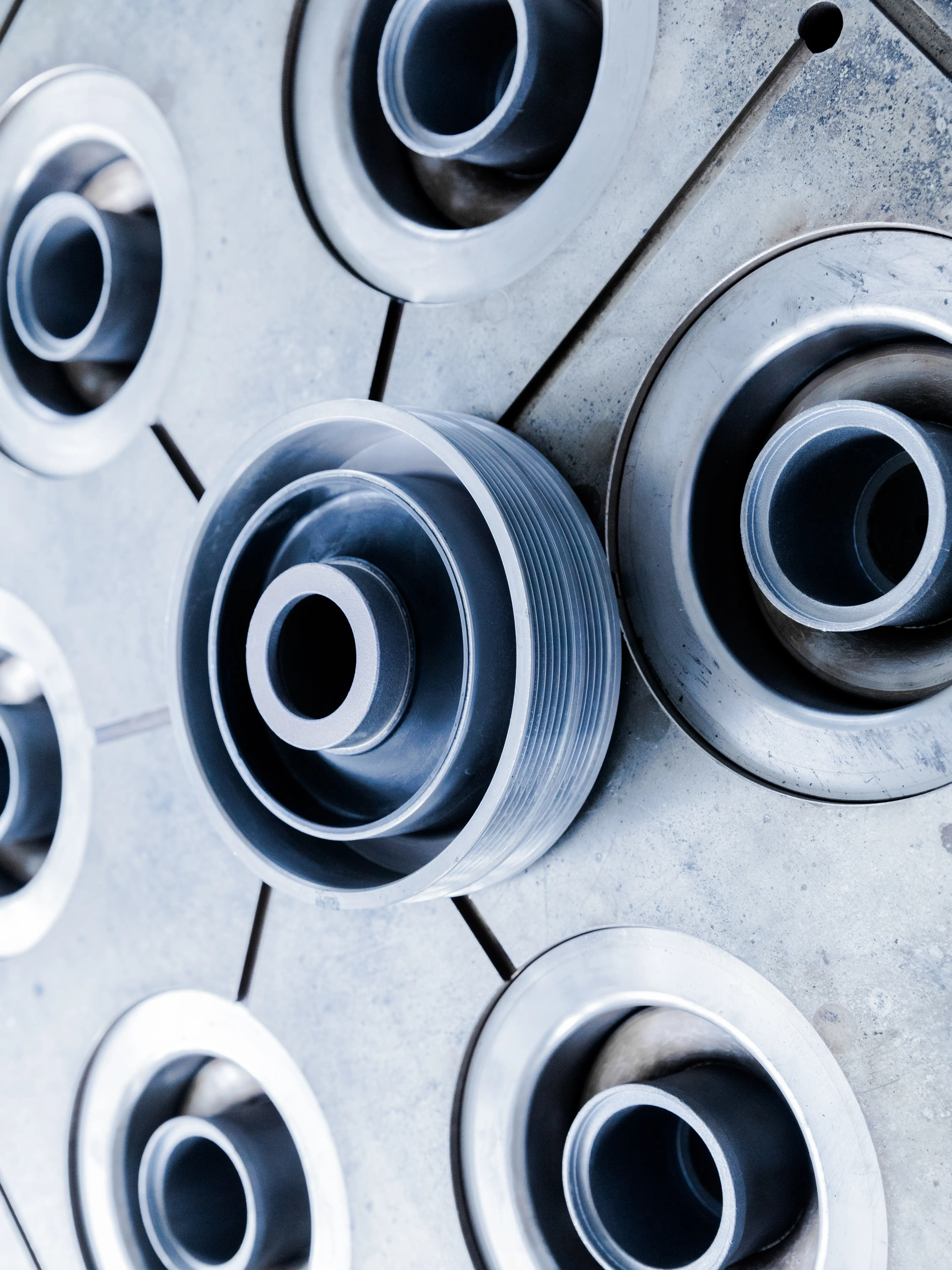 Close-up of six circular industrial metal components arranged in a hexagonal pattern on a metal surface.