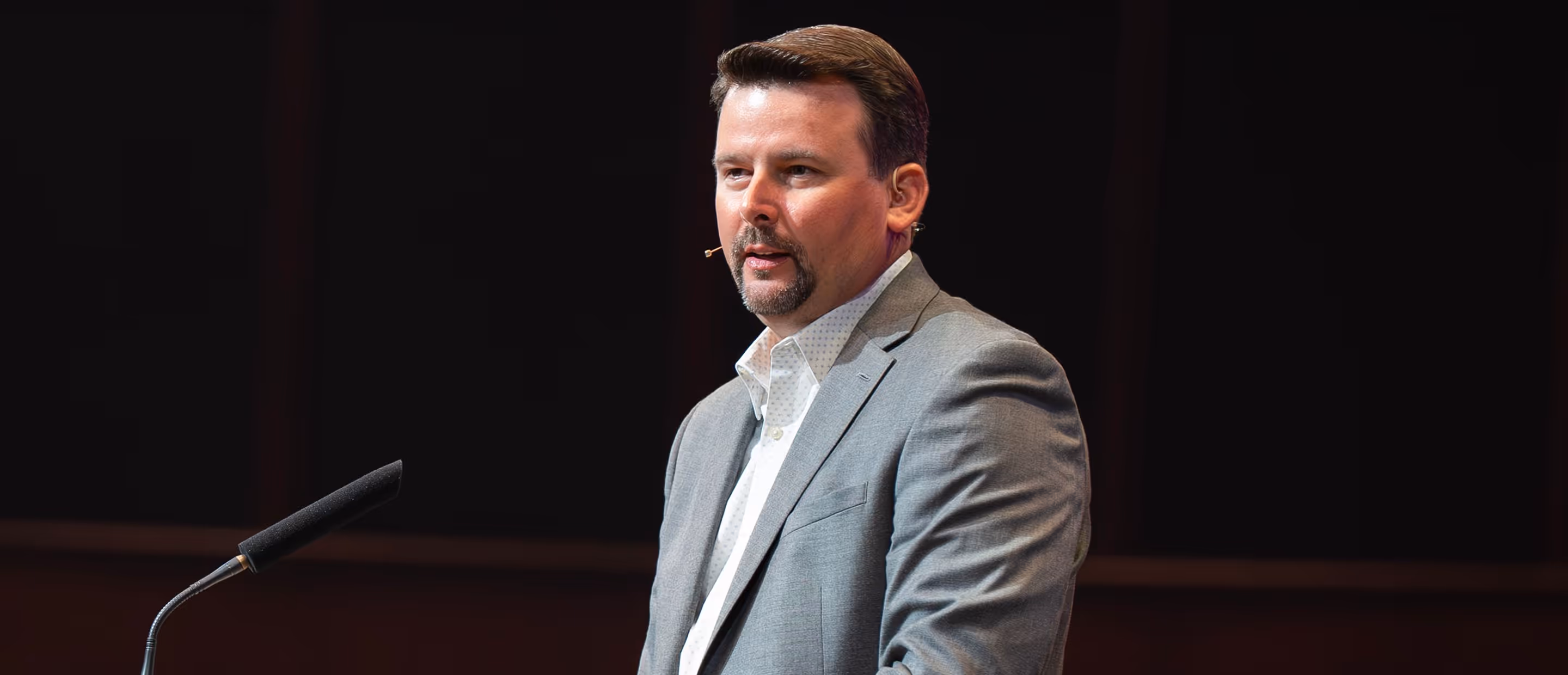 A man with a microphone preaching a sermon.