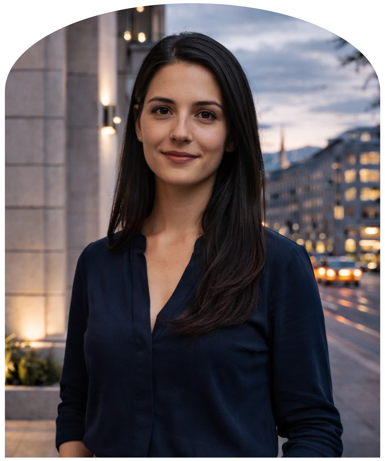 Julia Fernandez von findlocal.ch mit langen dunklen Haaren und dunklem Hemd vor einer abendlichen Stadtstraße mit beleuchteten Gebäuden.