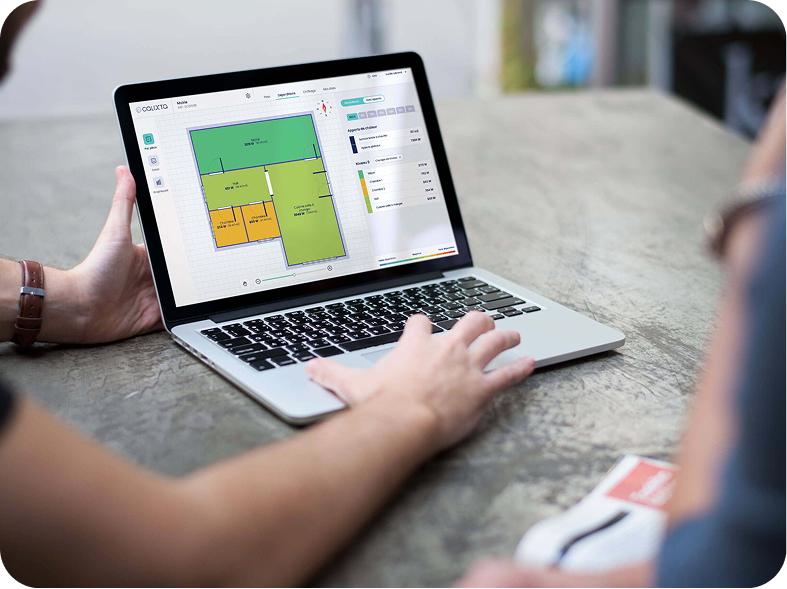Personne utilisant un ordinateur portable affichant un logiciel de plan d'étage avec différentes pièces colorées et leurs dimensions.