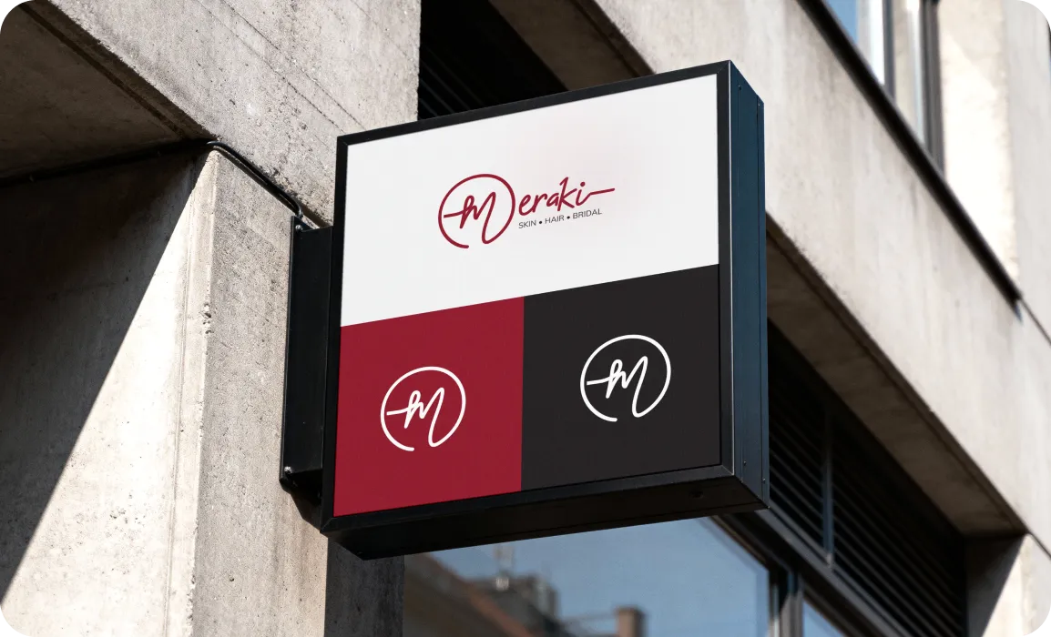 Square storefront sign with Meraki salon logo and text 'SKIN • HAIR • BRIDAL' mounted on a concrete building.