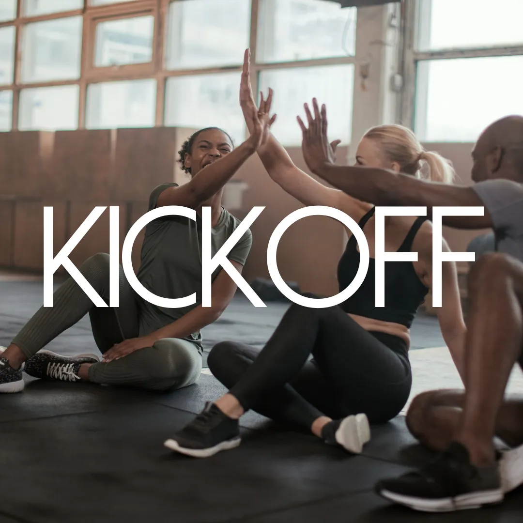 Tre personer i träningskläder som sitter på golvet i Jossamikas danshall och ger varandra high five efter ett pass.