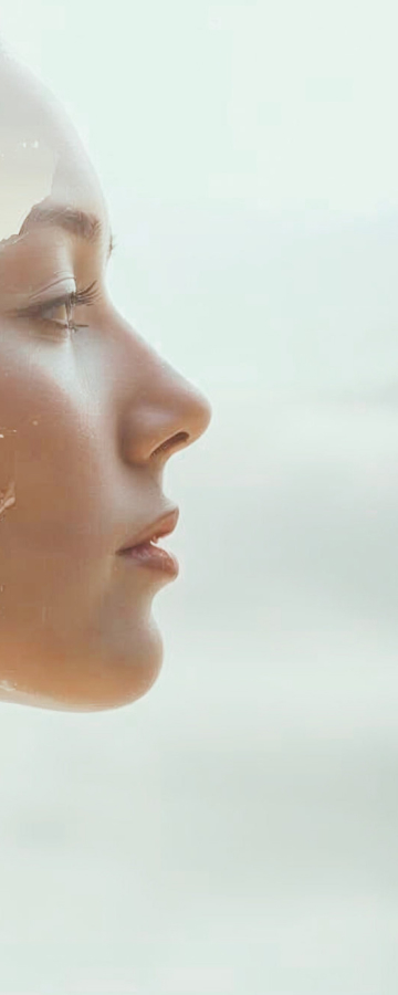 Profil d’une femme regardant l’horizon face à la mer, lumière douce et ambiance calme et méditative.