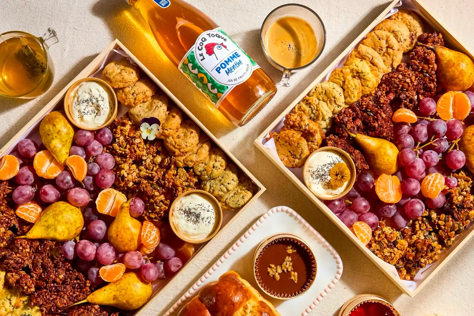 Planches traiteur gourmandes pour petit-déjeuner d'entreprise, garnis de fruits frais, cookies, granola et jus de pomme artisanal français.