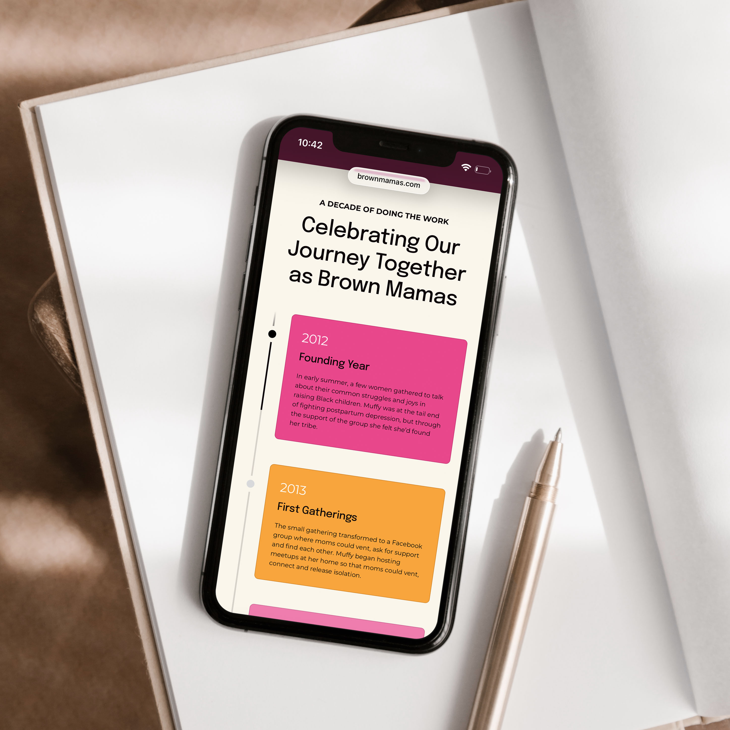 Brown Mamas mobile website design shown on a phone resting on a notebook, with a timeline titled "Celebrating Our Journey Together as Brown Mamas."