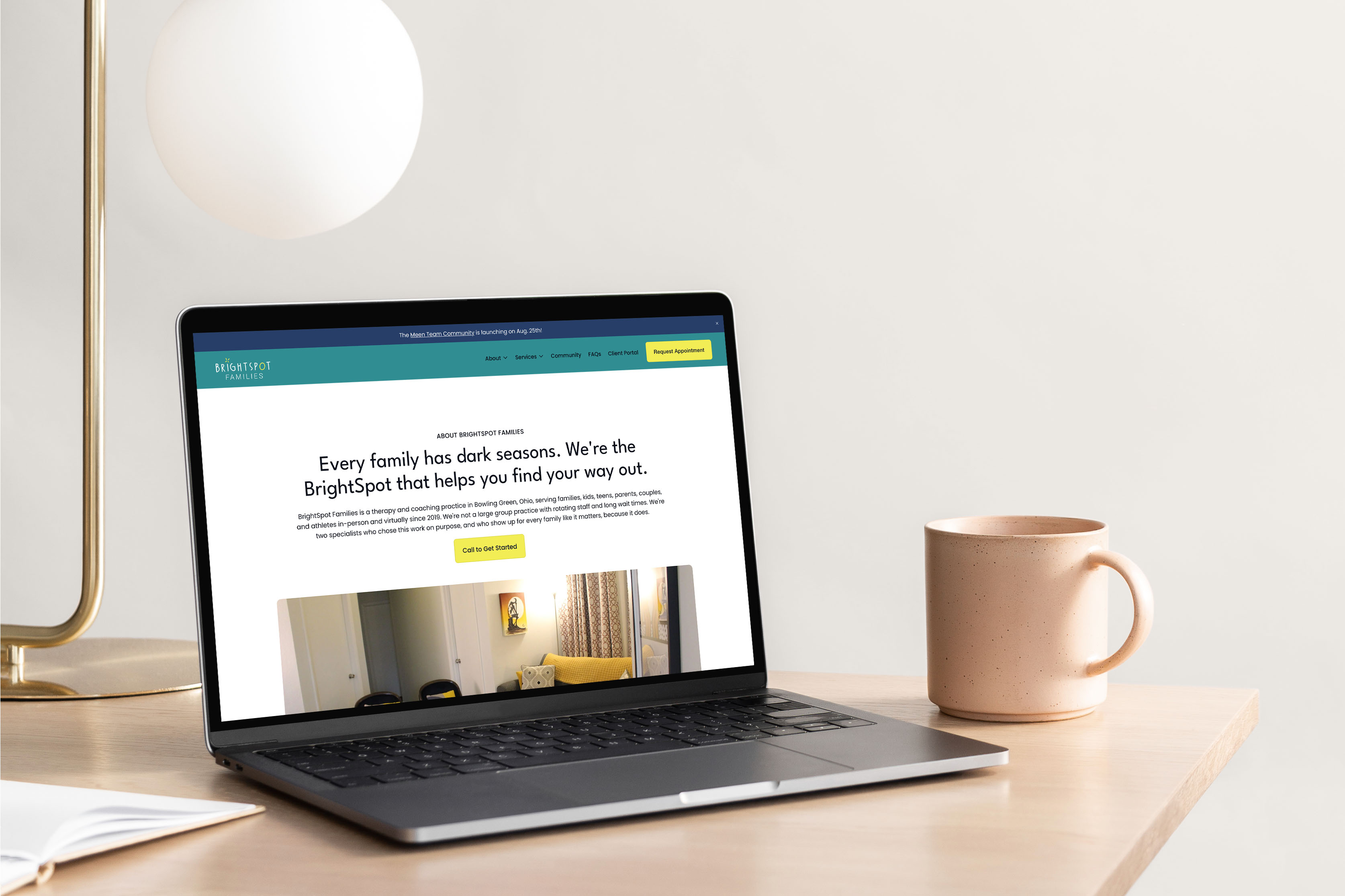 BrightSpot Families wellness website About page design shown on a laptop on a light wood desk, with the headline "Every family has dark seasons. We're the BrightSpot that helps you find your way out."