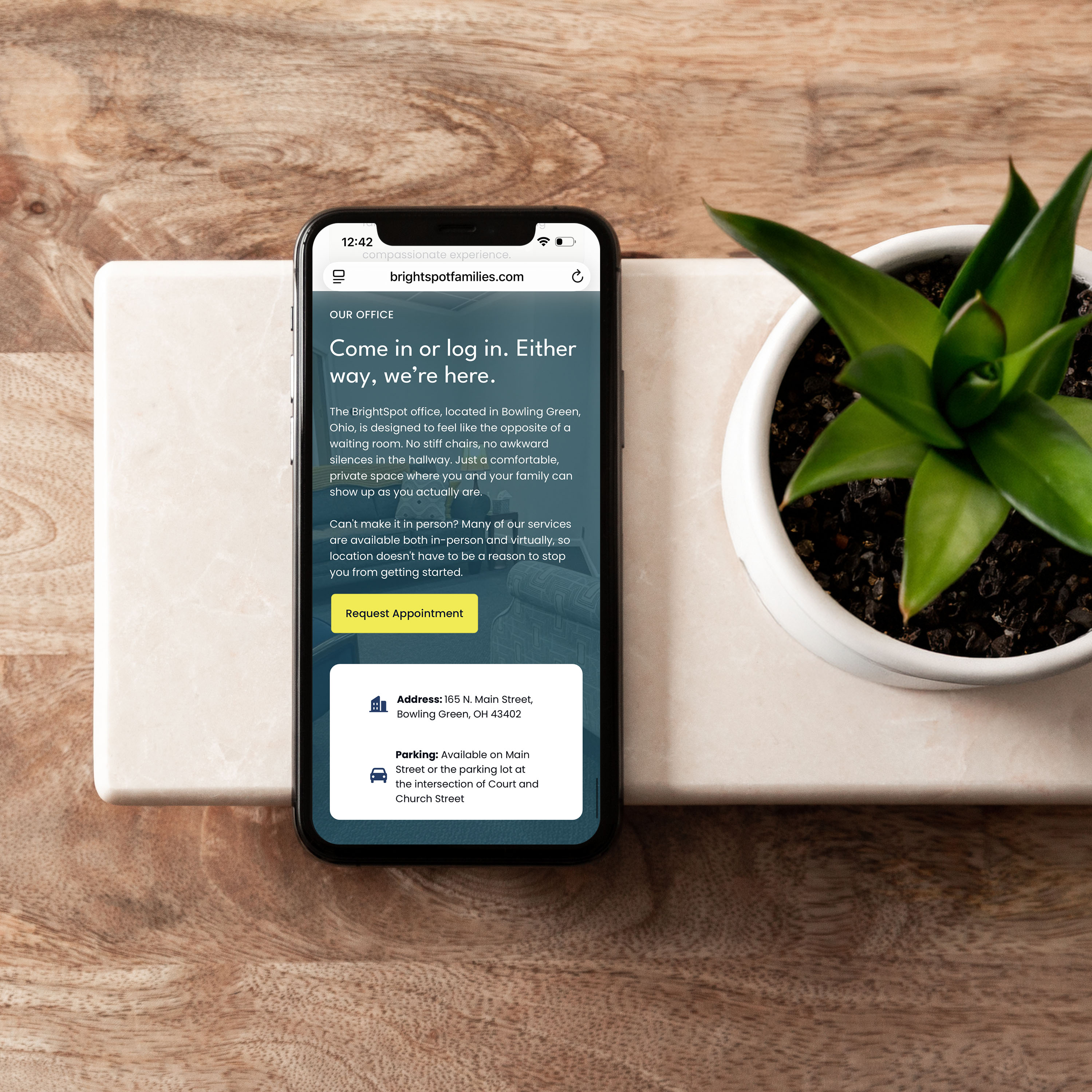 BrightSpot Families mobile website design shown on a phone beside a small potted plant, with the headline "Come in or log in. Either way, we're here."