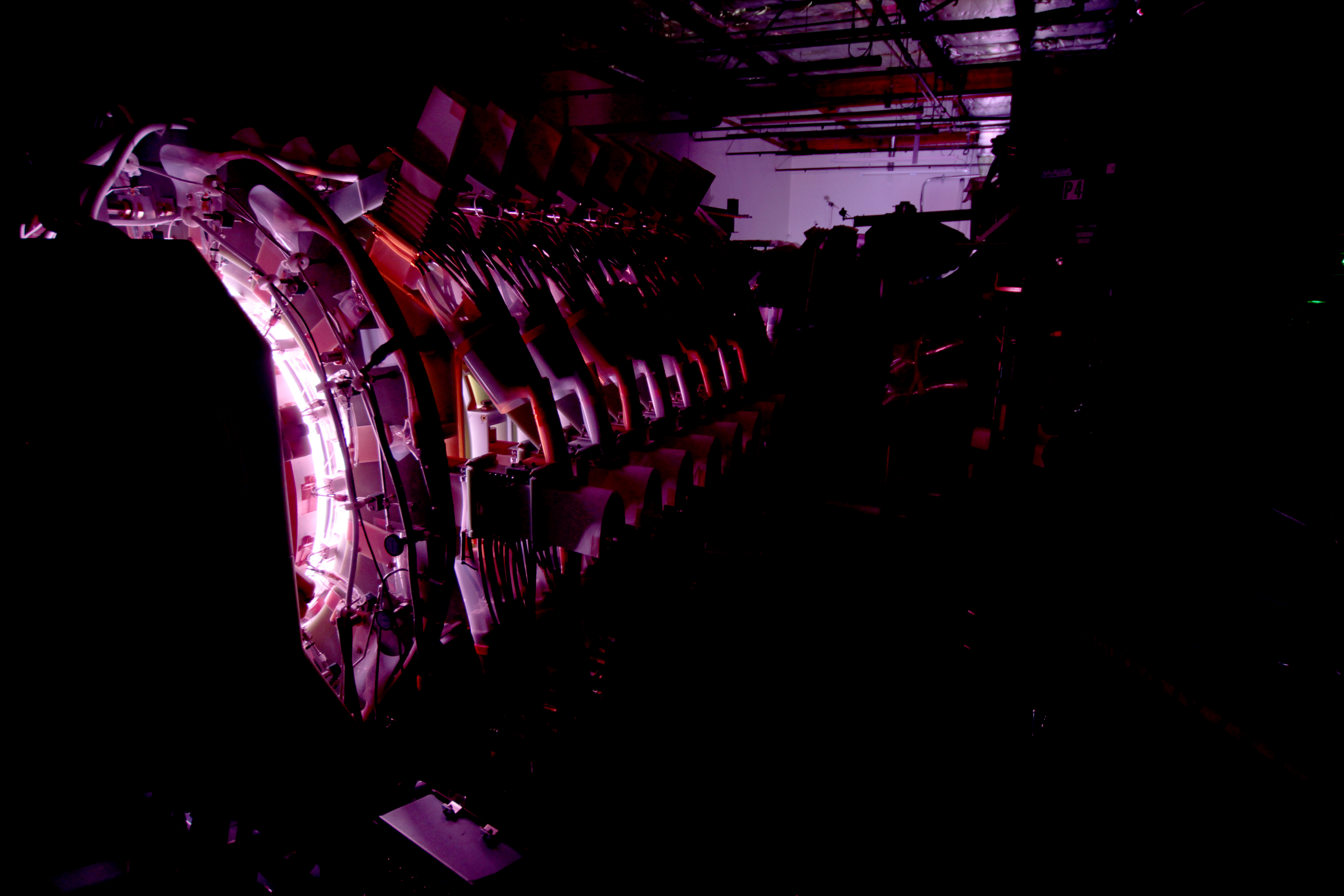 Partially illuminated Trenta fusion machine in a dimly lit room.