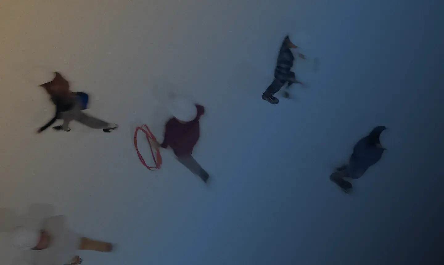 Overhead view of people walking on a gradient colored floor, carrying different supplies.