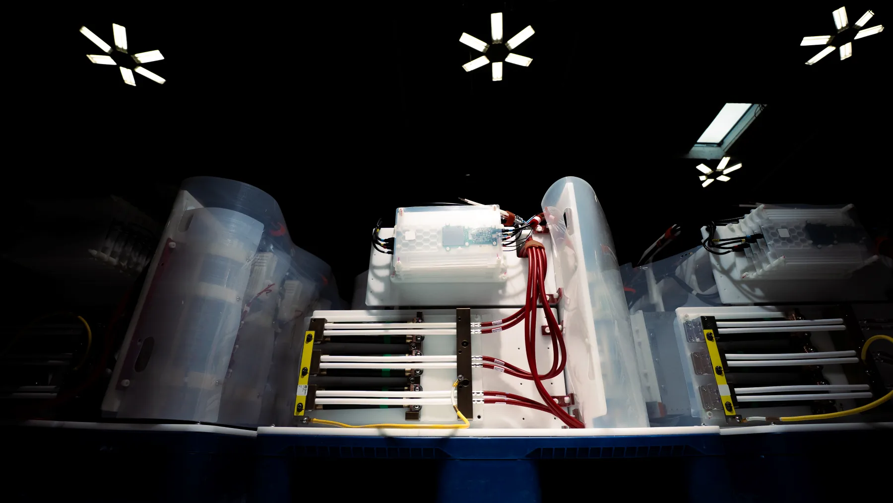 Close-up of a capacitor with red and yellow cables connected inside a translucent cover.