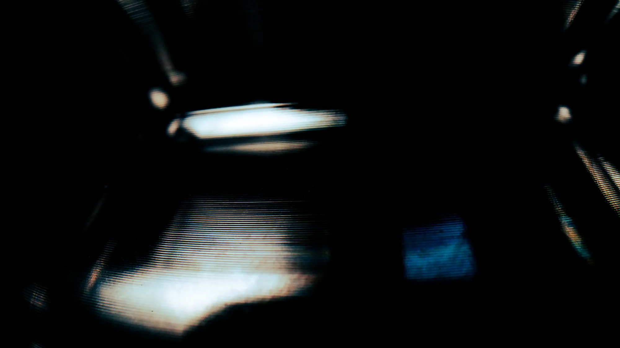 Abstract dark background with blurred and distorted horizontal light lines in white and blue hues.