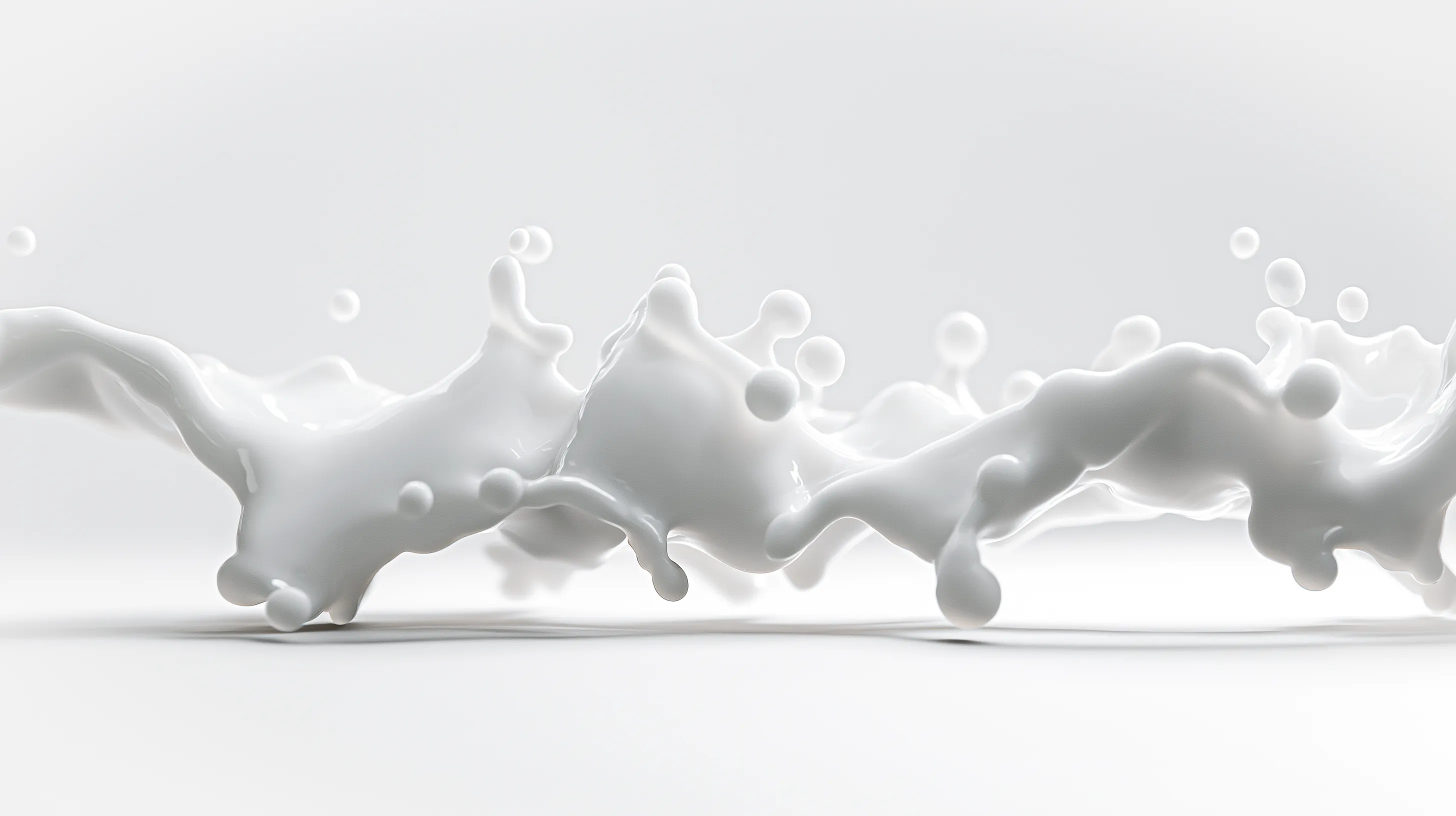 Splashing white milk liquid forming dynamic shapes and droplets on a white surface.