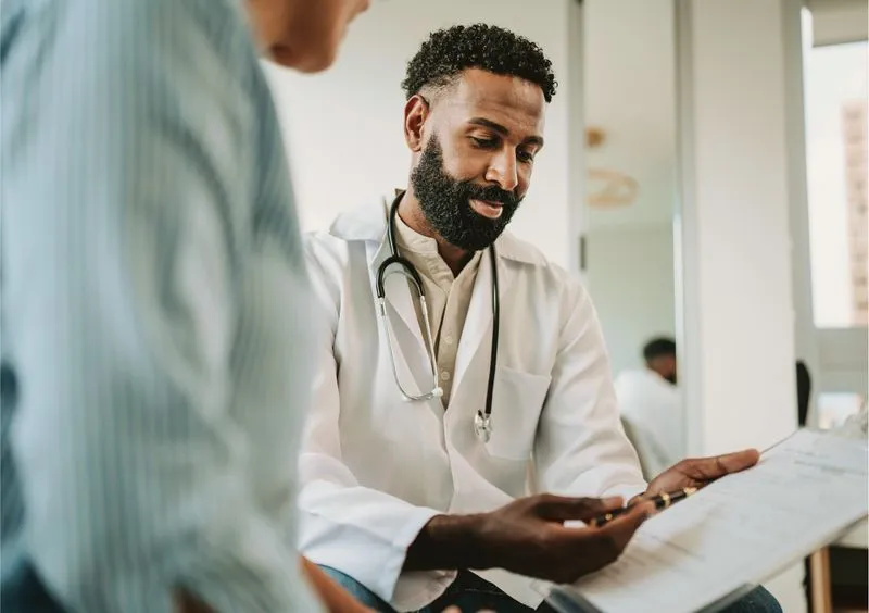 doctor showing a patient a paper on a clipboard