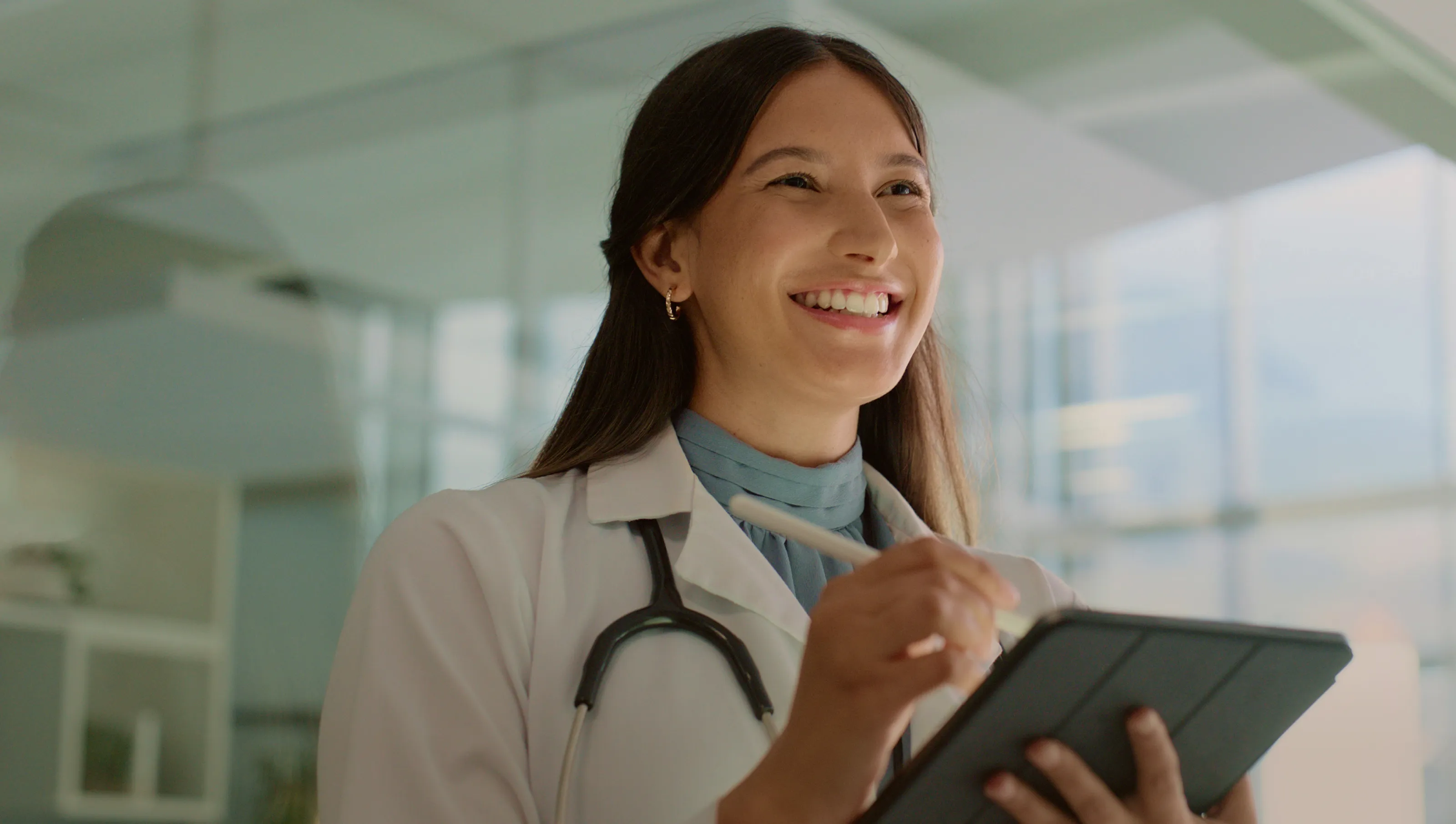 doctor smiling holding a tablet
