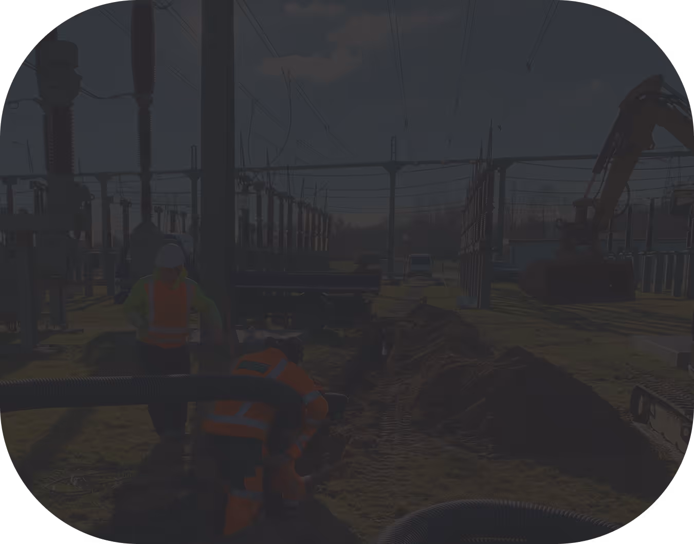 Arbeiter in Warnwesten bei Grabungsarbeiten in einer Umspannstation mit einem Bagger im Hintergrund.