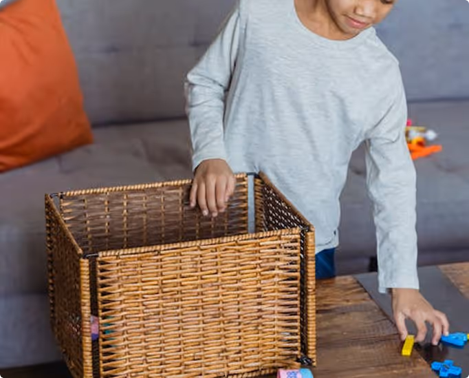 A young child picks up colourful toy blocks from a table, capturing a moment of everyday play used to observe behaviour and attention.