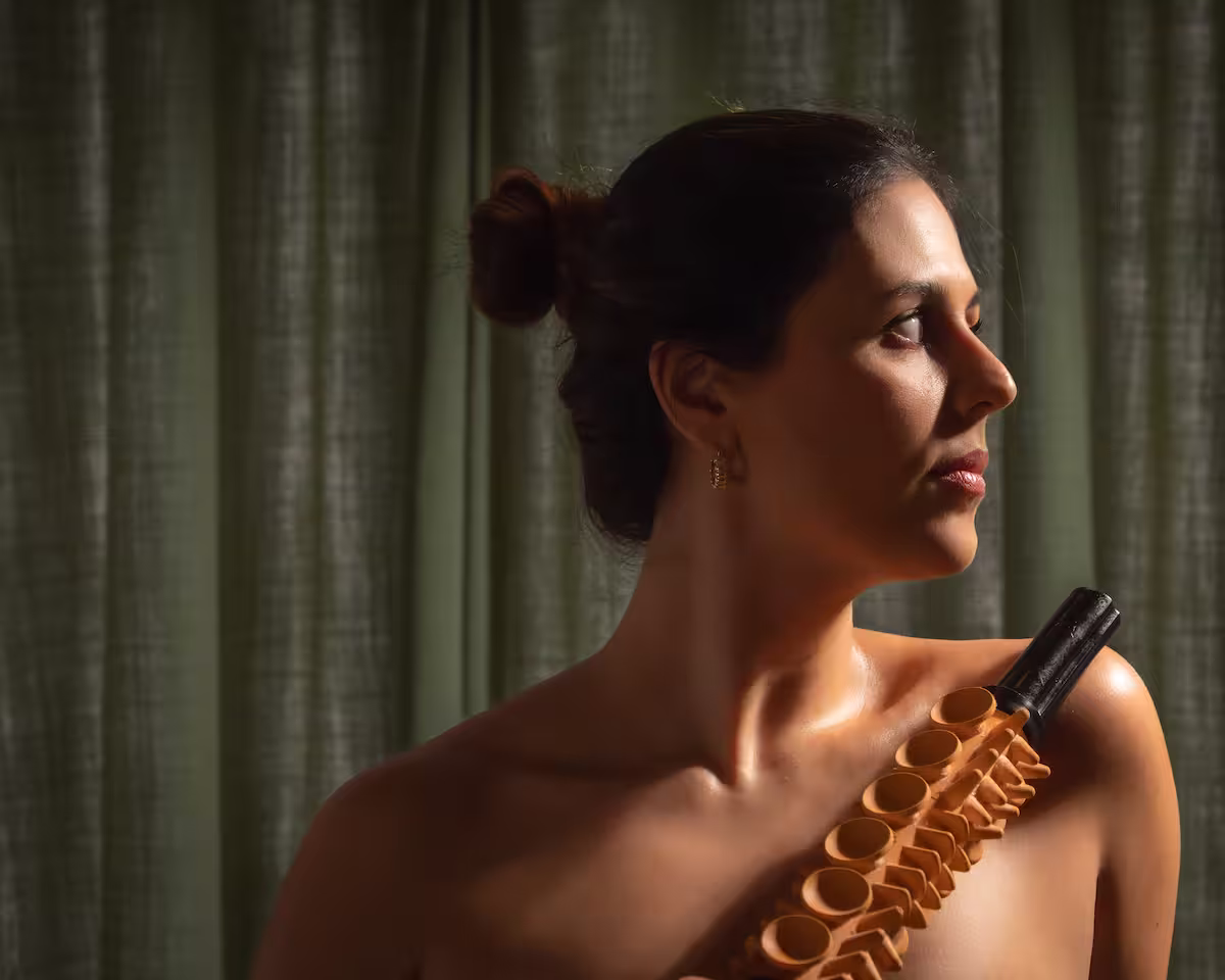 Mujer de perfil con el cabello recogido, fotografiada con luz cálida.