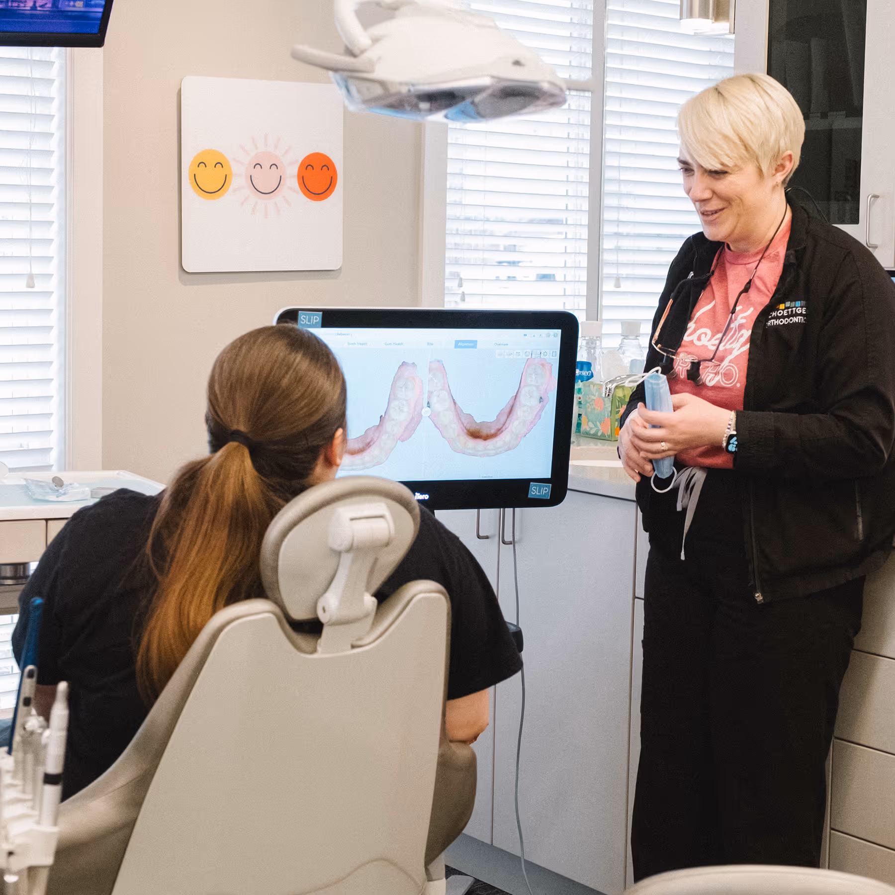 Orthodontist showing dental 3D scans of teeth to patient in dental office.