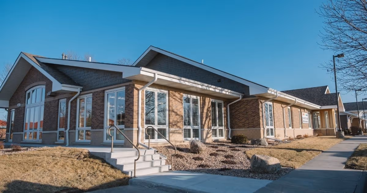 Schoettger Orthodontics Lincoln brick building with large windows and steps under clear blue sky.