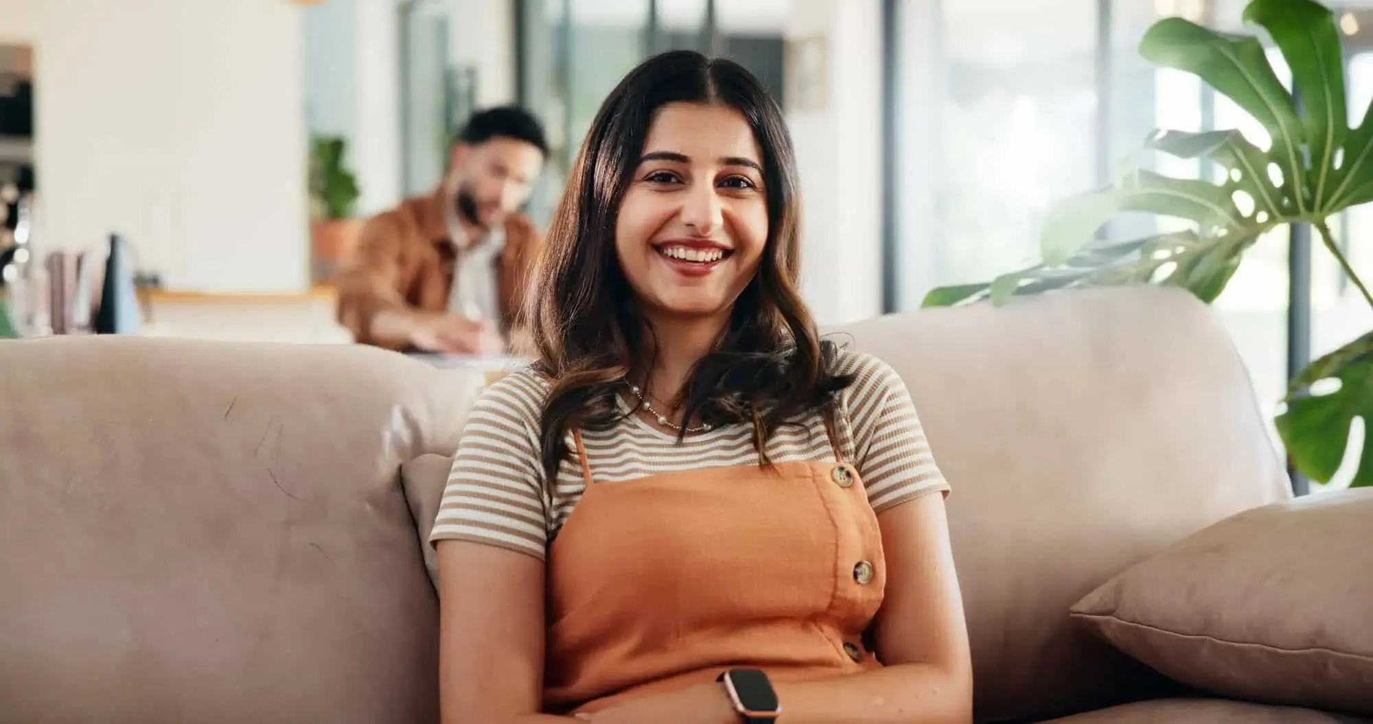 Woman smiling while seated in a community center.