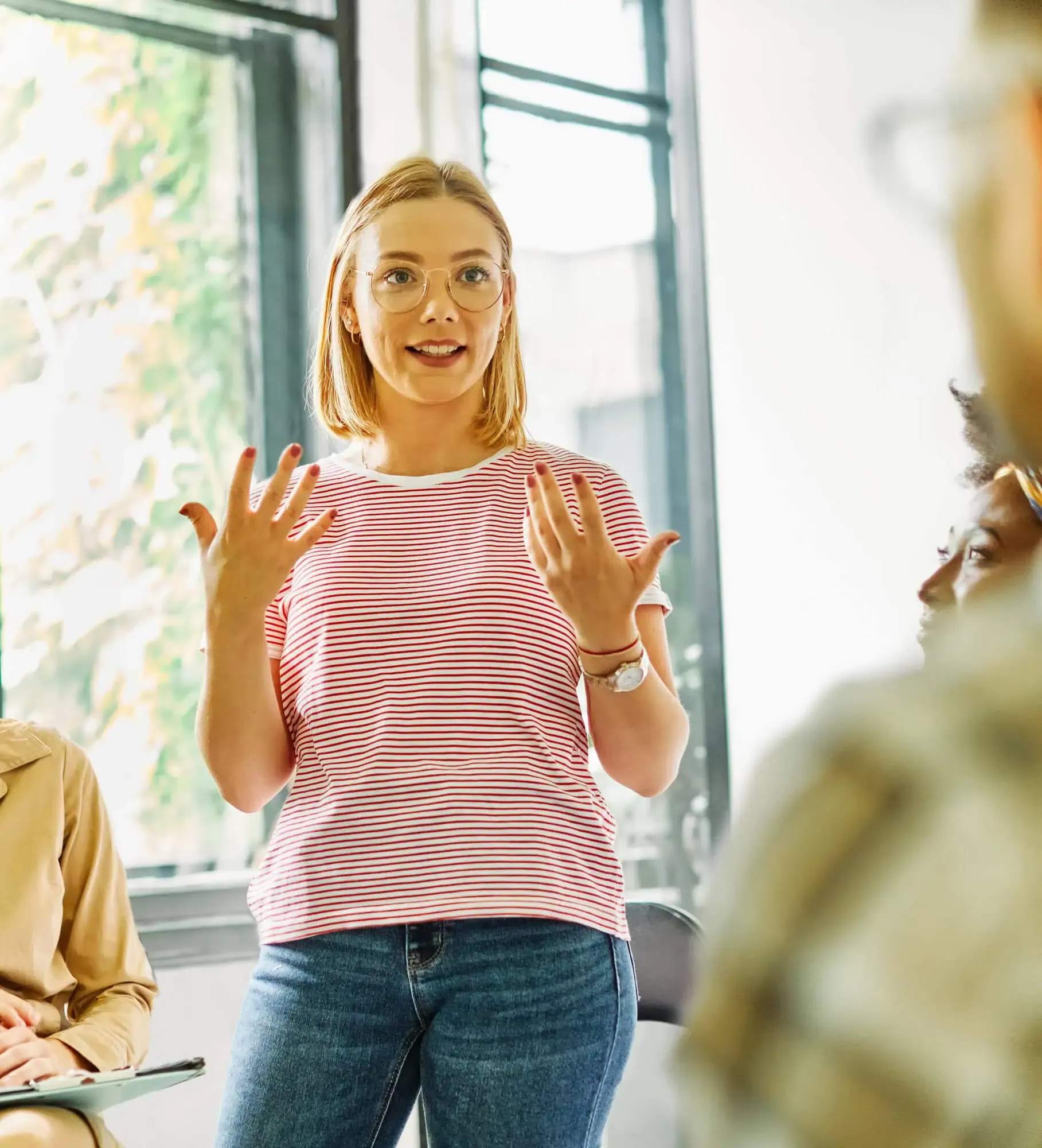 A woman standing in front of a group of people.