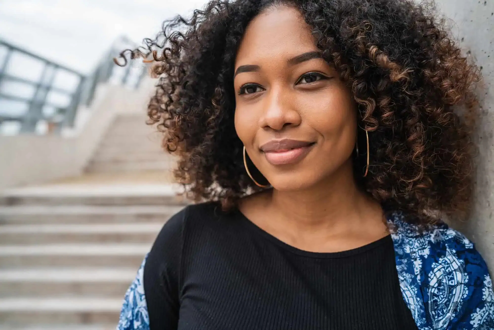 A close up of a person with curly hair.