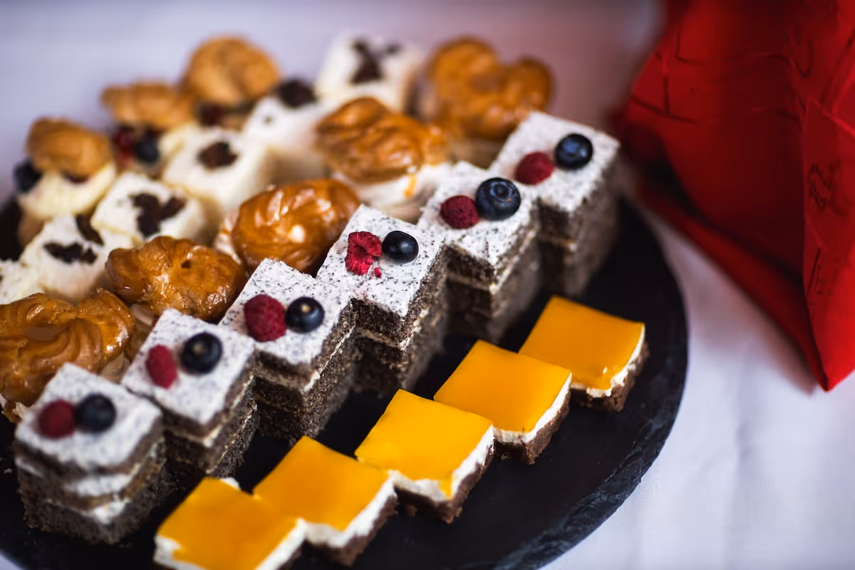 Svadobný candy bar s minidezertmi, zákuskami a ovocím na sladkom stole.