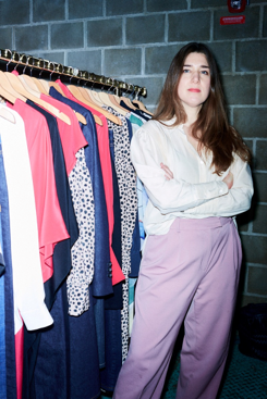 Wendy Heijne, Founder of Studio Heijne and CEO of ShapelyTech, standing beside a rack of made-to-measure garments