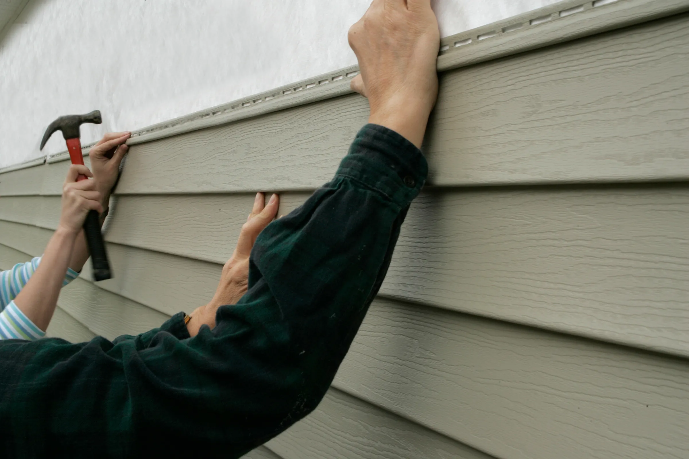 Siding replacement in progress on a two-story home