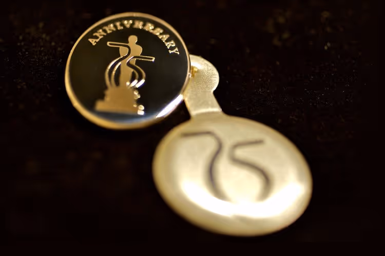 Gold-colored 75th anniversary pin featuring an Oscar and the number 75 - gold enamel pin