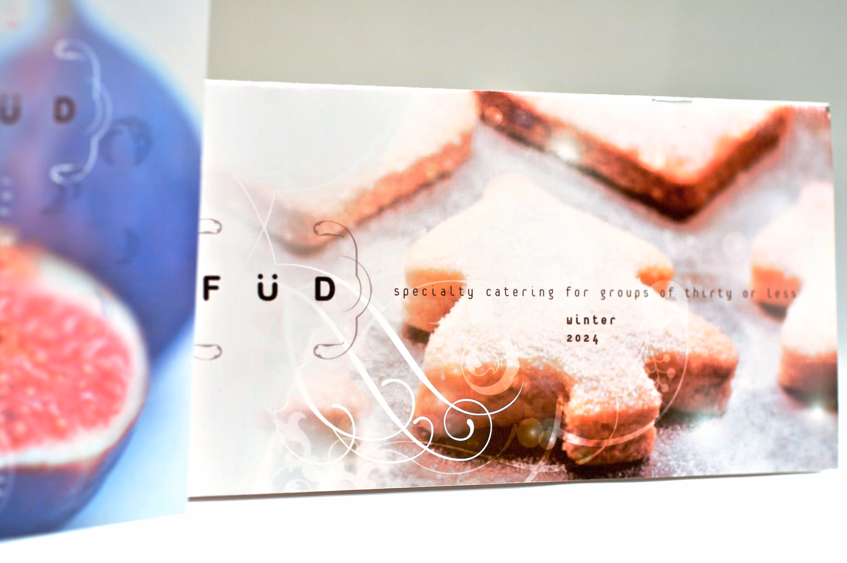 Holiday-themed star-shaped cookies dusted with powdered sugar alongside text about specialty catering for groups of thirty or less in winter 2024.