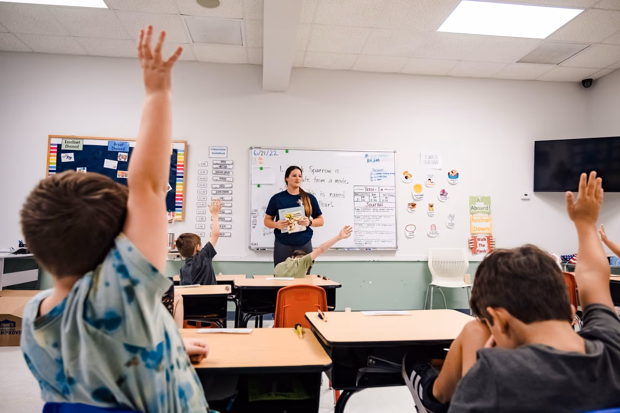 BIG classroom with students raising their hands