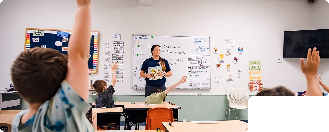 BIG classroom with children raising their hands